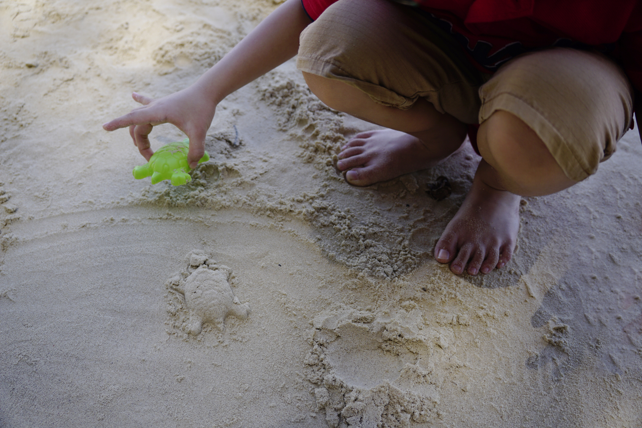 Children enjoying unstructured play in a large indoor sandbox at Sandmagination.