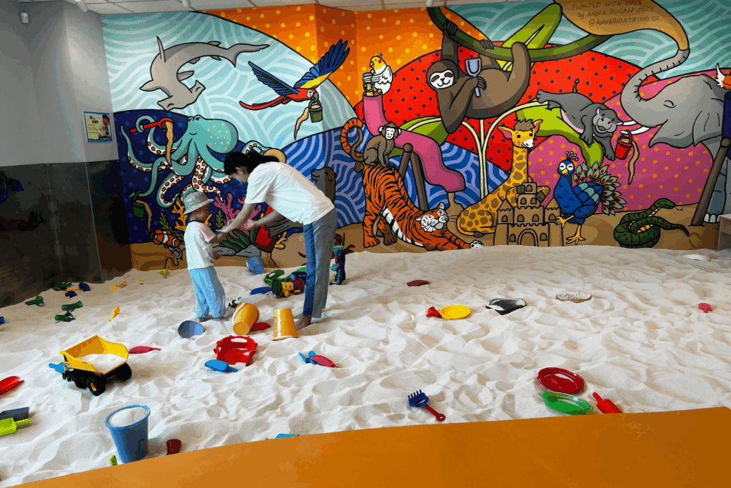 Kid and parent playing at sandmgination