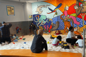 Kids and parents playing at Sandmagination's indoor sandbox