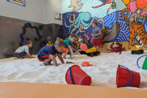 Kids happily having a good time at Sandmagination's indoor sandbox