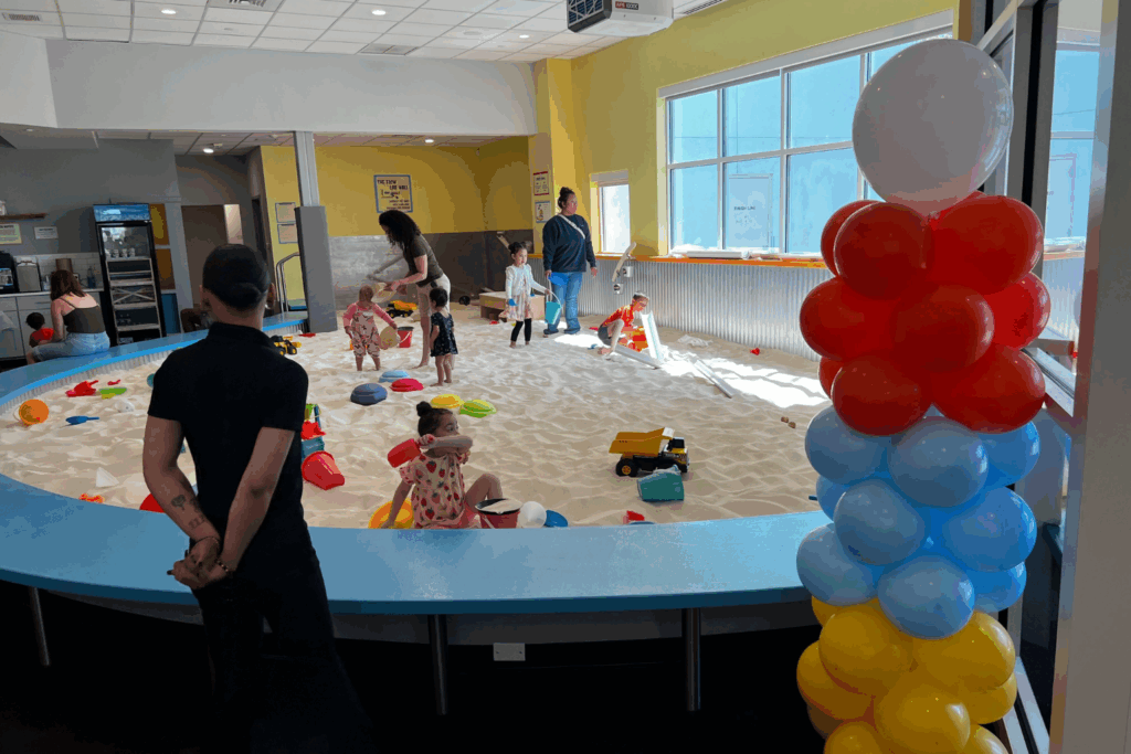 Parents and their children playing in the sandbox at sandmagination